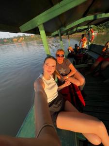 马尔多纳多港Tronco Tambopata Adventure的两个女人坐在水面上的船上