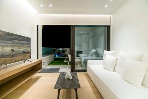 锡蒂亚GM exclusive Luxury Suites & SPA的客厅配有白色沙发和平面电视。
