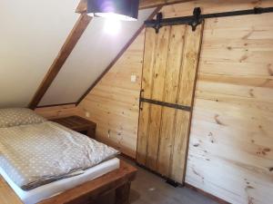 ŘekaChalupa Řeka - Na samotě u lesa的一间卧室设有一张床和木墙