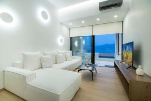 锡蒂亚GM exclusive Luxury Suites & SPA的客厅配有白色沙发和电视