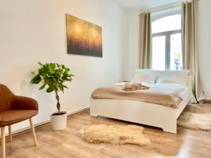 汉诺威Golden Deer Apartment - 3 Schlafzimmer - Zentrum - 92m²的一间卧室配有床、椅子和植物