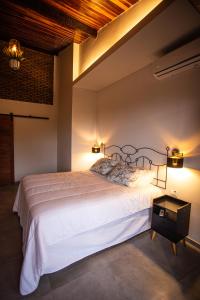 费尔南多 - 迪诺罗尼亚Pousada Vila Nakau的卧室配有一张白色大床和两个灯