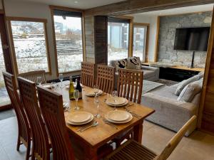 蒂涅Ski in-Ski out! Spacious & Stylish Apartment for 8 in the heart of Lavachet的一间带桌子和沙发的用餐室