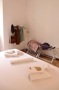 阿奎泰尔梅Cozy Flat in Piemonte的配有带毛巾和婴儿床的床的客房