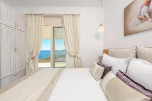 克里斯阿穆迪亚Villa Niti的一间白色的卧室,配有一张床,享有海景
