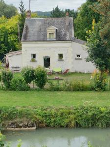 谢尔河畔努瓦耶Petite maison au bord du canal, 8' Zoo de Beauval, PMR的河前的白色房子,带两把椅子