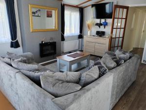 亨斯坦顿Dog Friendly 8 Berth Lodge, 600 Yard's From The Beach In Hunstanton的客厅配有大沙发和桌子