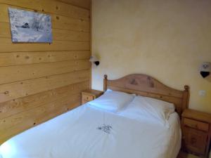 萨莫安斯La Ferme d'Henriette, à Samoëns的卧室配有白色的木墙床