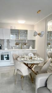 詹塔尔LuxApart Apartamenty Jantar的白色的厨房配有桌椅