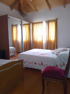 特雷利乌Muy Patagónica, Casa de Campo的一间卧室配有两张床、窗帘和椅子