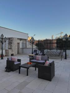普蒂尼亚诺Dolce Farinella的屋顶上设有带沙发和桌子的庭院。