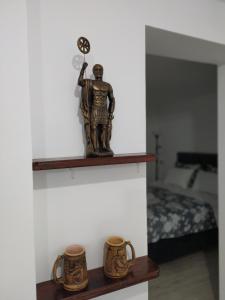 尼什Zamak的架子上一个男人的雕像,有两杯