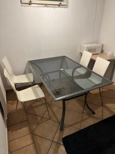 SödervärnRum C的玻璃桌和两张白色椅子