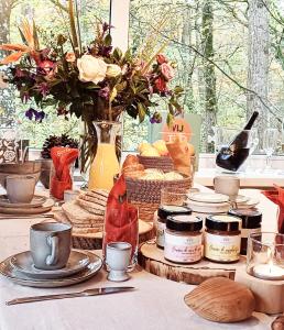 杜柏A Wood Lodge - zwembad - relax - natuur的餐桌,上面有盘子和罐子,食物和鲜花