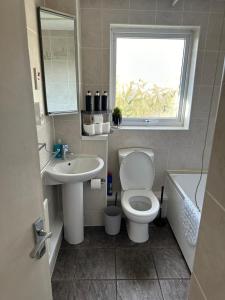 查塔姆Home in Medway 3bedroom free sports channel, parking的一间带卫生间、水槽和窗户的浴室