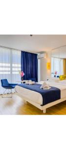 巴统Lux Apart Hotel 555的一间卧室配有一张大床和一张蓝色椅子