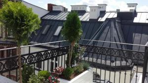 波兹南Fortune Old Town boutique hotel的一座黑色和白色的建筑,阳台上种植了植物