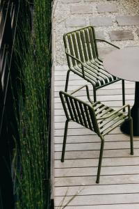 维希Maison Decoret - Relais & Châteaux的木甲板上配有两把椅子和一张桌子