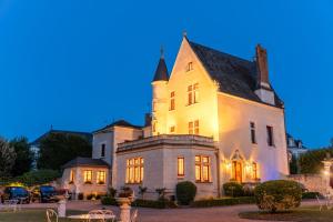 阿姆博斯马诺尔圣托马斯酒店的一座白色的大房子,灯火通明