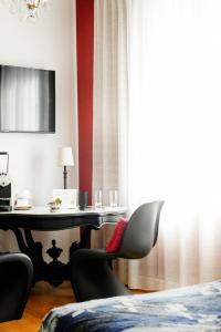 维希Maison Decoret - Relais & Châteaux的客房设有桌椅和窗户。