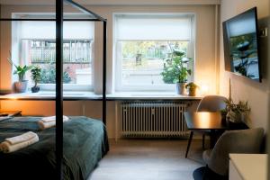 汉堡City Center Unique Boutique Apartment的一间卧室配有一张床、一张书桌和两个窗户。