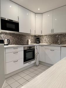 斯德哥尔摩Apartment with amazing view的白色的厨房配有白色的橱柜和微波炉