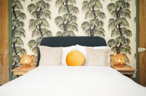 谢菲尔德Hamilton House的一间卧室配有一张带白色床罩和棕榈树壁纸的床
