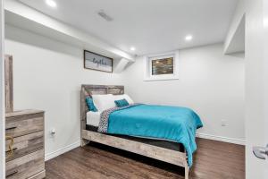 坎布里奇Modern 1 Bedroom + Den in Cambridge的卧室拥有白色的墙壁和蓝色床单。