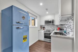 坎布里奇Modern 1 Bedroom + Den in Cambridge的厨房配有蓝色冰箱,设有白色橱柜
