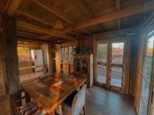 普腊亚罗萨Pousada Vale da Magia的小屋内带木桌的用餐室