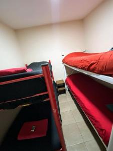 厄尔查尔坦Hostel El Paredon的红色床单的客房内的两张双层床