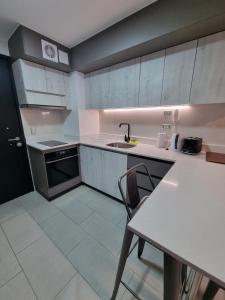特木科Apartamentos Bauerle Curitiba的厨房配有白色橱柜、桌子和水槽。