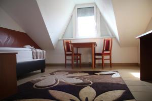 德布勒森Auguszta Hotel és Diákszálló的卧室配有一张床和一张桌子及椅子