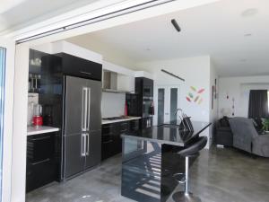 Cable BayEagle View的厨房配有黑色橱柜和不锈钢冰箱