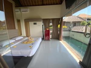 金巴兰巴厘岛金象精品别墅的一间卧室设有一张床和一个游泳池