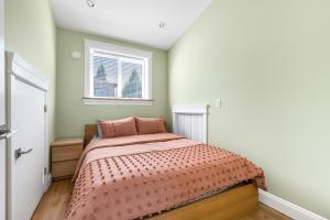 温哥华Three bedrooms brand new laneway house near public transit的一间卧室配有一张带粉红色棉被的床