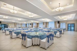 张家界张家界专家村阳光庭院酒店的大型宴会厅配有蓝色和白色的桌椅