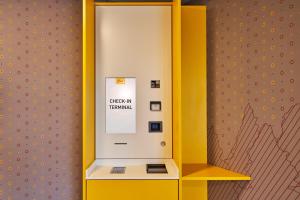 杜塞尔多夫杜塞尔多夫麦克吉姆斯酒店的客房内的黄色和白色售票机