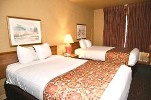NewportFortune Inn & Suites的酒店客房设有两张床和窗户。