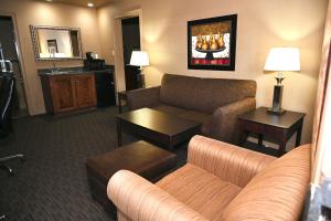 NewportFortune Inn & Suites的酒店客厅配有沙发和桌子