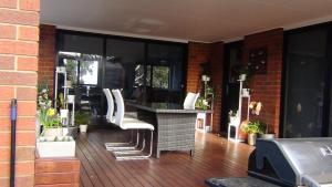 霍巴特Tranquil Retreat 10 Min to Hobart-WIFI Smart TV的庭院配有桌子和白色椅子