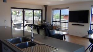 霍巴特Tranquil Retreat 10 Min to Hobart-WIFI Smart TV的一个带水槽的厨房和一间客厅