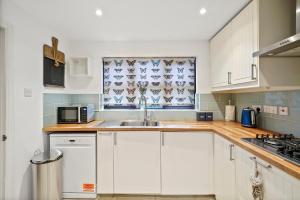 StoneBeautiful 5 bedroom house in Stone, Aylesbury, Free parking的厨房配有白色橱柜和水槽