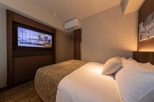奈良Iroha Grand Hotel Kintetsu Nara Ekimae的配有一张床和一台平面电视的酒店客房