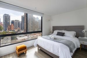 波哥大Loft nuevo, moderno, central的一间卧室设有大窗户和一张大床