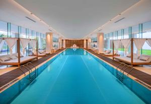 三亚三亚海棠湾茅台度假村茅台精品酒店的大楼内带椅子的大型游泳池