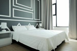 东贡岸ITCC Manhattan Suites by Pinstay Premium的卧室设有白色的床和大窗户