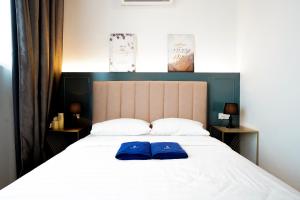 东贡岸ITCC Manhattan Suites by Pinstay Premium的床上有2个蓝色枕头