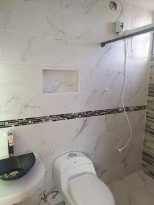 安巴托4 Suite Balcón estelar Ambato的白色的浴室设有卫生间和水槽。