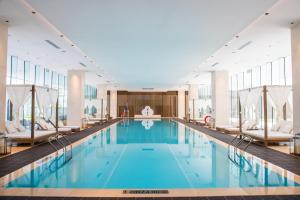 三亚三亚海棠湾茅台度假村茅台珍品酒店的大楼内带椅子的大型游泳池